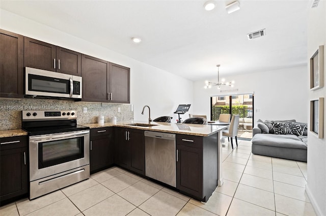 4641 Caspian Way, Davie, FL 33314 - kitchen featuring appliances with stainless steel finishes, a sink, a peninsula, open floor plan, and backsplash