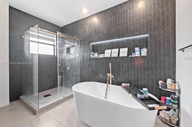 bathroom with shower with separate bathtub, tile patterned floors, and tile walls