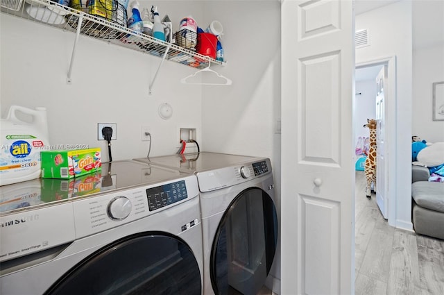 laundry room with independent washer and dryer and light wood-type flooring