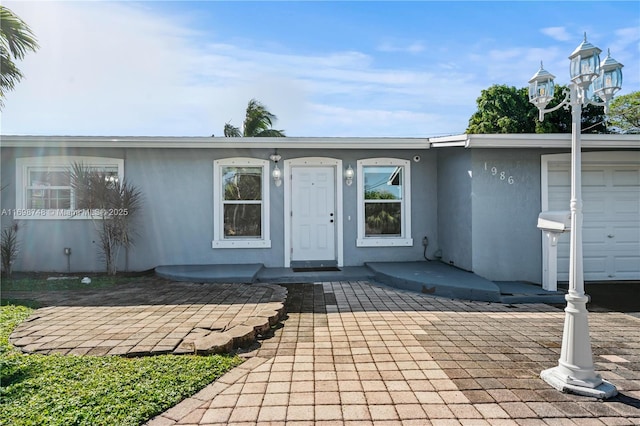 exterior space featuring an attached garage and stucco siding