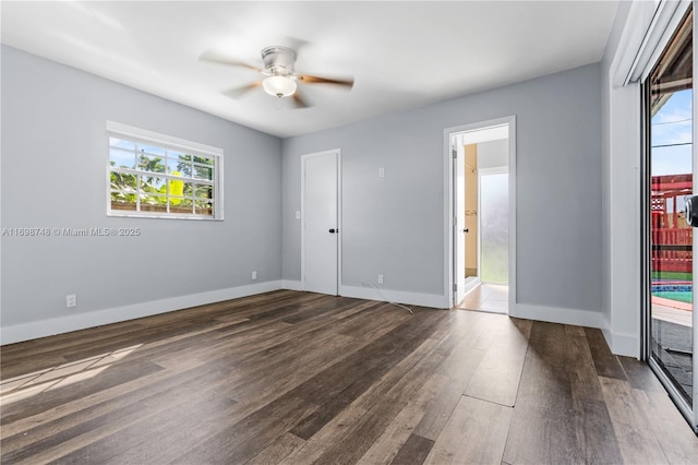 unfurnished room featuring dark wood-type flooring, baseboards, and a ceiling fan