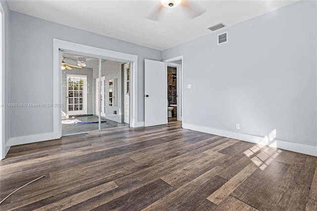 empty room featuring baseboards, wood finished floors, visible vents, and a ceiling fan