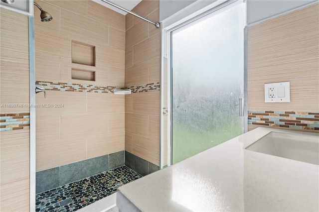 bathroom featuring a tile shower and tile walls