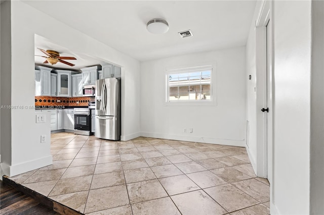 kitchen with ceiling fan, gray cabinets, tasteful backsplash, light tile patterned flooring, and stainless steel appliances