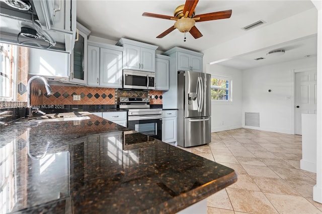 kitchen with backsplash, visible vents, stainless steel appliances, and a sink