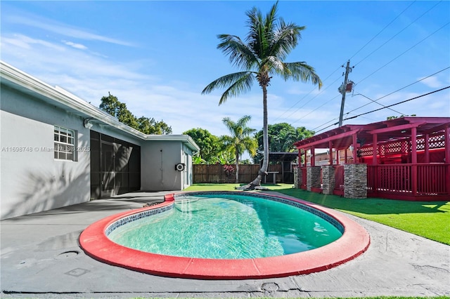 view of swimming pool featuring a patio area, fence, a fenced in pool, and a yard