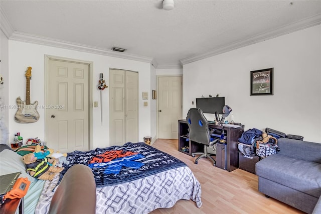 bedroom with hardwood / wood-style flooring, crown molding, and a textured ceiling