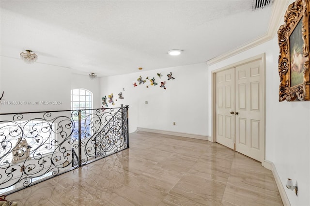 corridor featuring crown molding and a textured ceiling