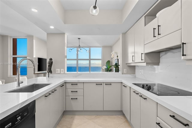 kitchen with pendant lighting, black appliances, sink, and an inviting chandelier