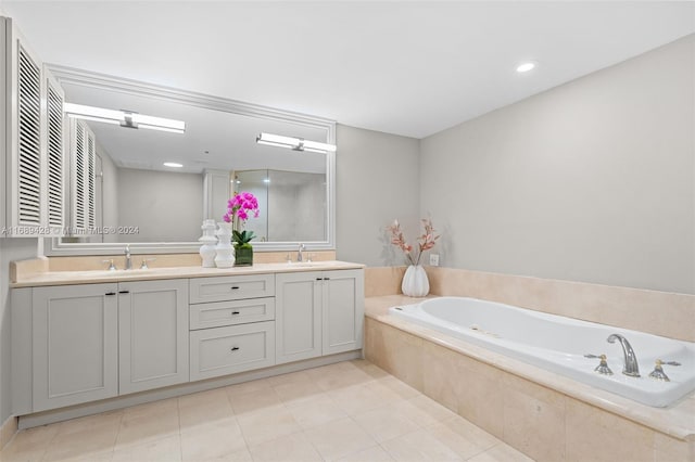 bathroom featuring tile patterned floors, vanity, and a relaxing tiled tub