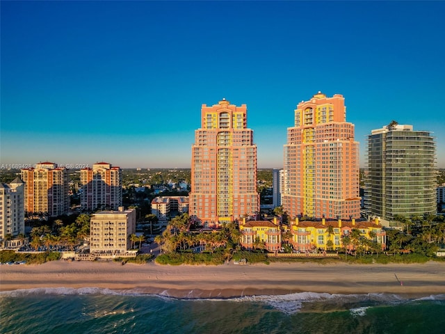 property's view of city featuring a water view and a beach view