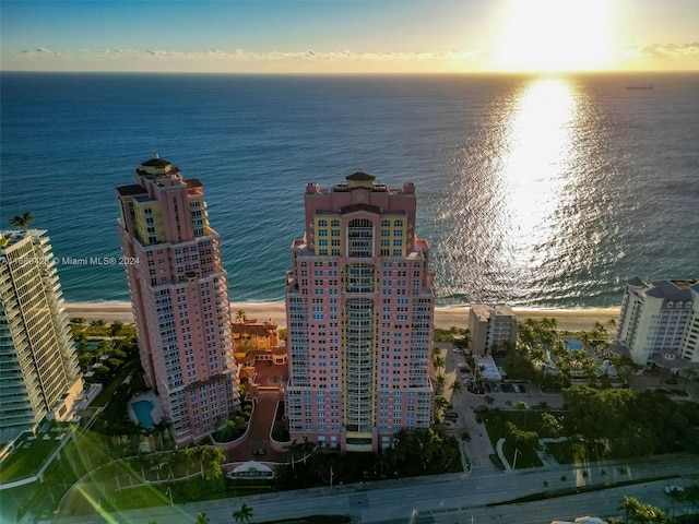 aerial view at dusk featuring a water view