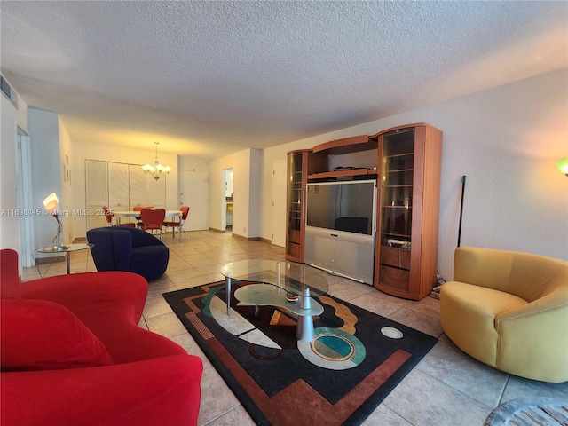 living room featuring a textured ceiling, light tile patterned floors, and a notable chandelier