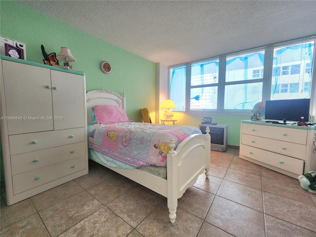 bedroom with a textured ceiling and tile patterned flooring