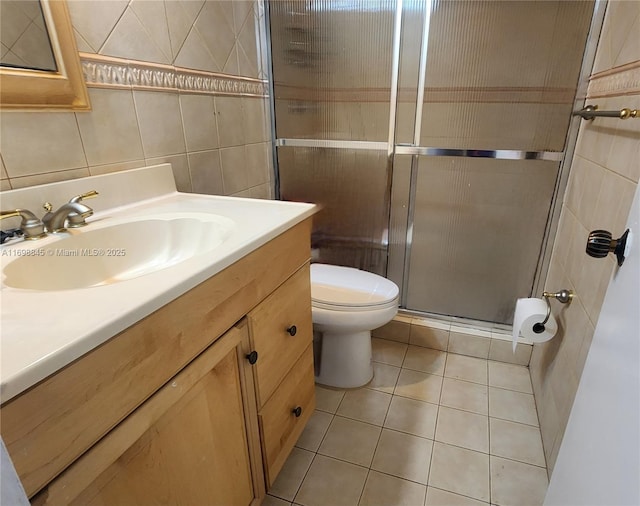 bathroom featuring an enclosed shower, tile patterned floors, tile walls, toilet, and vanity