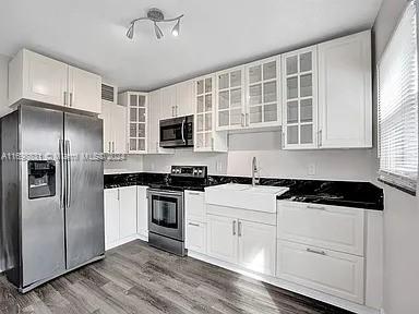 kitchen featuring white cabinets, sink, dark hardwood / wood-style flooring, and stainless steel appliances