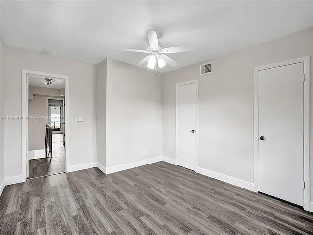 spare room with ceiling fan and dark wood-type flooring