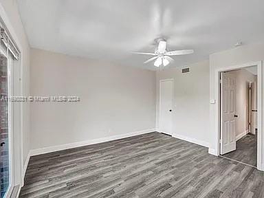 spare room with ceiling fan and dark hardwood / wood-style flooring