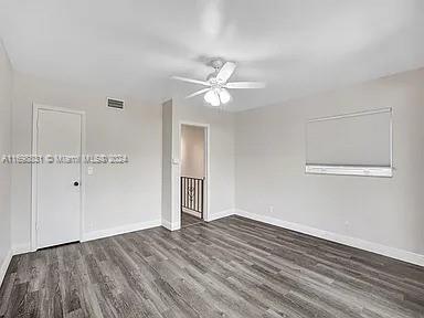 empty room featuring ceiling fan and dark wood-type flooring