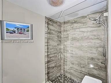 bathroom featuring a shower with shower door