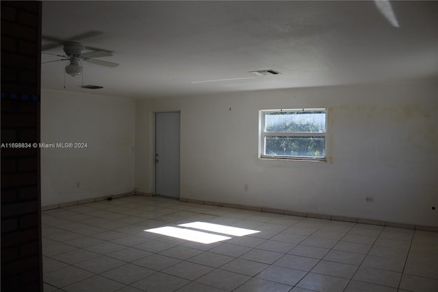 spare room with ceiling fan and light tile patterned floors