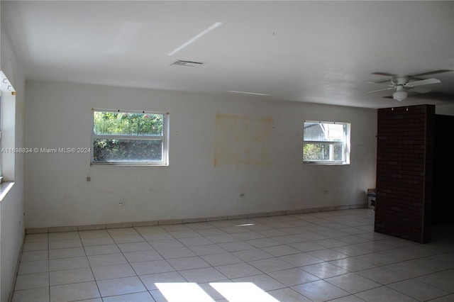 spare room with ceiling fan, a healthy amount of sunlight, and light tile patterned flooring