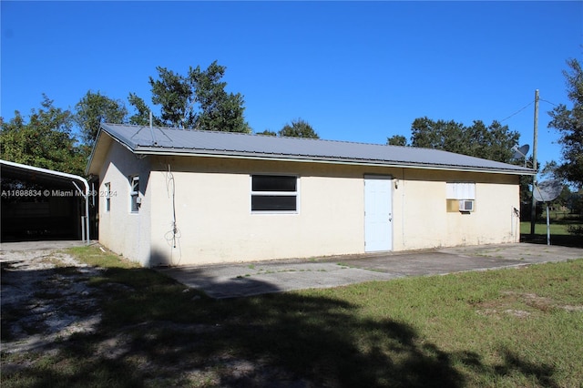 rear view of house featuring a yard and a carport