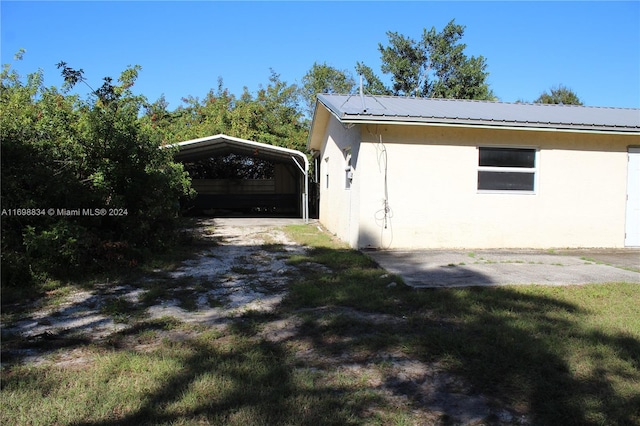 view of home's exterior featuring a carport and a lawn