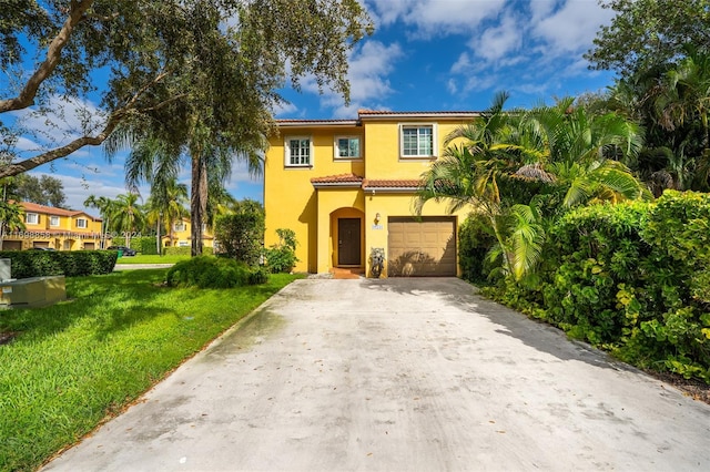 mediterranean / spanish-style home featuring a front lawn and a garage