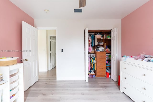 bedroom with light hardwood / wood-style floors, a closet, and ceiling fan