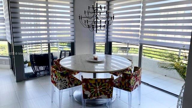 tiled dining room with a notable chandelier