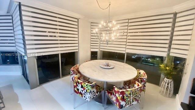 dining space with a chandelier and crown molding