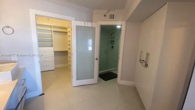 bathroom featuring tile patterned floors, vanity, ornamental molding, and walk in shower