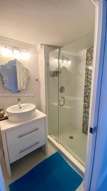 bathroom with tile patterned flooring, vanity, and walk in shower