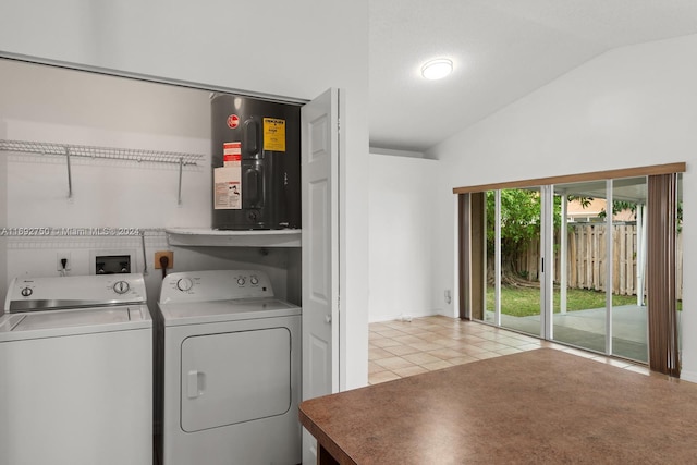 clothes washing area featuring washer and dryer, light tile patterned floors, and water heater