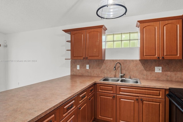 kitchen with backsplash, black range with electric stovetop, sink, and a textured ceiling