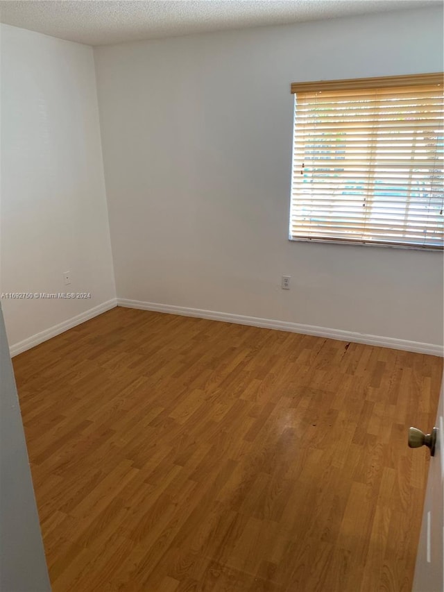 spare room with wood-type flooring and a textured ceiling