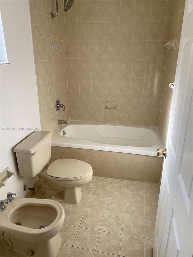 bathroom with tile patterned floors, toilet, tiled shower / bath, and a bidet