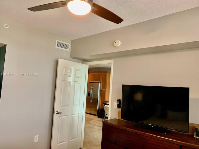 tiled living room featuring a textured ceiling and ceiling fan