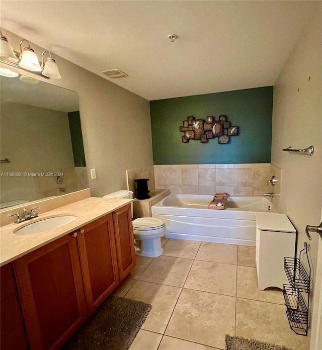 bathroom featuring tile patterned flooring, vanity, toilet, and a bathing tub