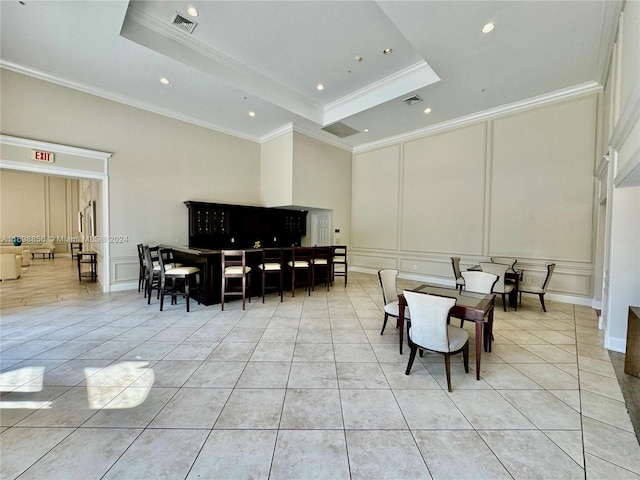 tiled dining room with a raised ceiling and crown molding