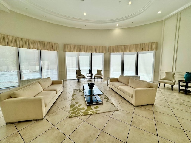 living room with crown molding, light tile patterned floors, and a high ceiling