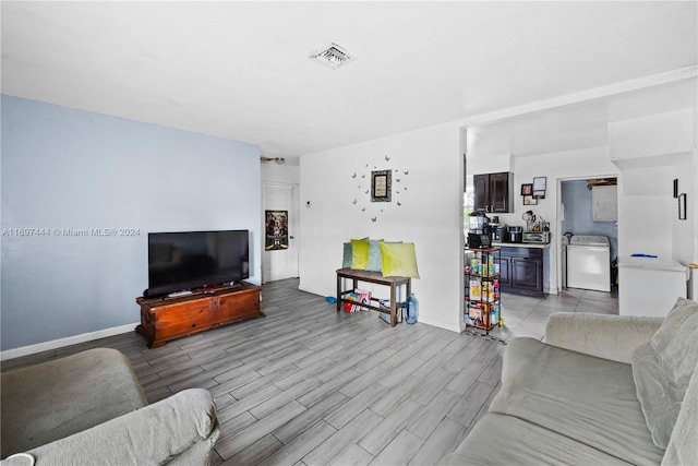 living room with light wood-type flooring and washer / clothes dryer