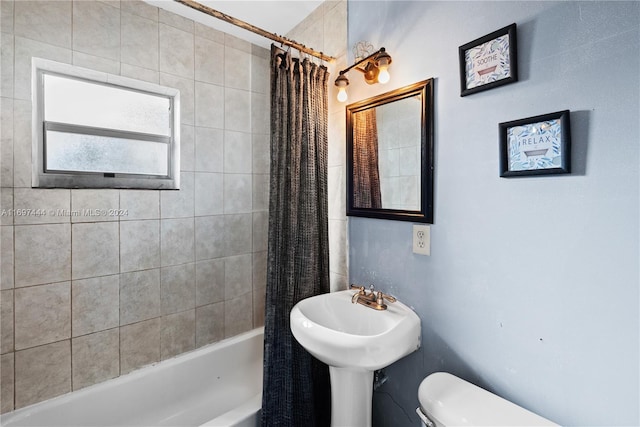 full bathroom featuring toilet, shower / bathtub combination with curtain, and sink