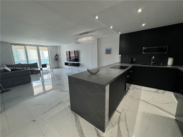 kitchen with kitchen peninsula, light stone countertops, black electric stovetop, and sink