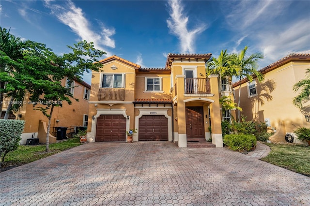 mediterranean / spanish-style house with a garage and a balcony