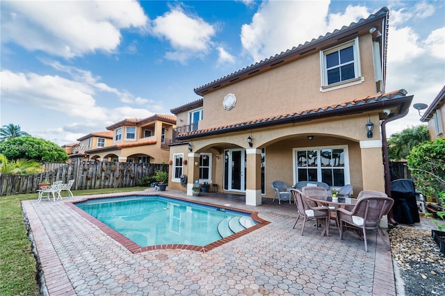 back of house featuring a fenced in pool and a patio