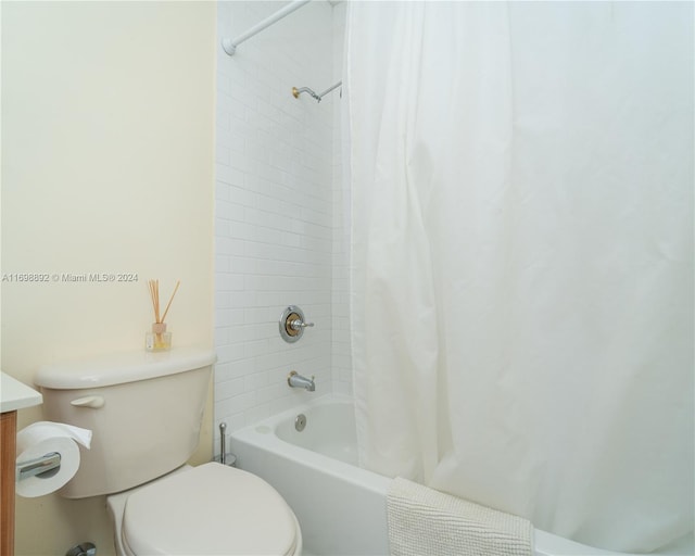 bathroom featuring toilet and shower / bath combo with shower curtain