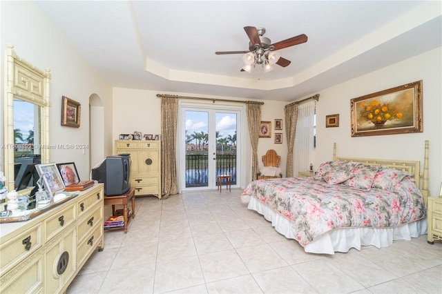 bedroom with ceiling fan, light tile patterned flooring, a raised ceiling, and access to outside