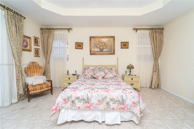 tiled bedroom with a raised ceiling